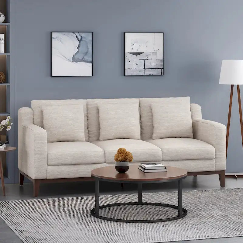 Un canapé trois places moderne avec coussins décoratifs.