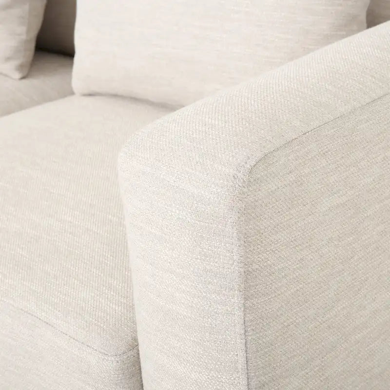 Un canapé trois places moderne avec coussins décoratifs.