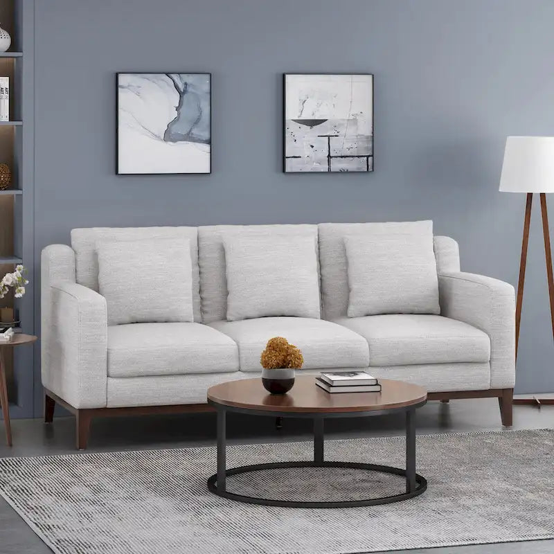 Un canapé trois places moderne avec coussins décoratifs.