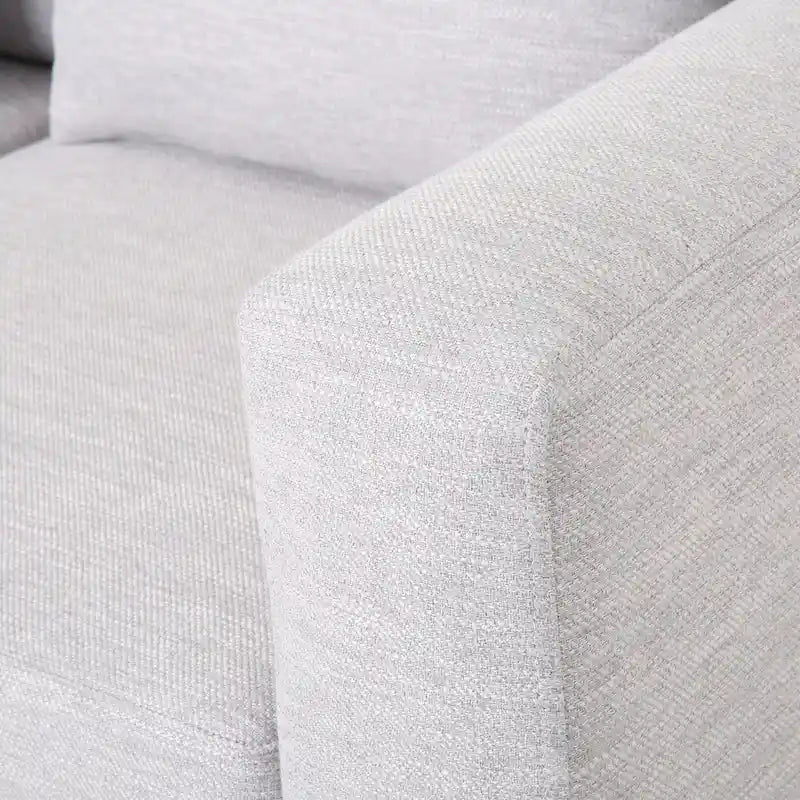 Un canapé trois places moderne avec coussins décoratifs.