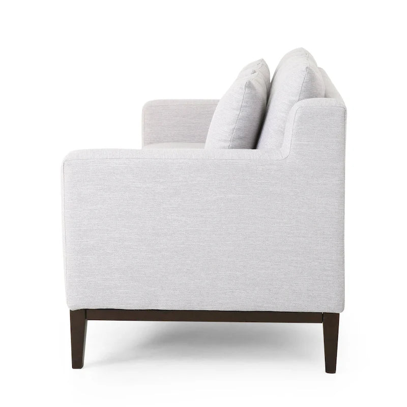 Un canapé trois places moderne avec coussins décoratifs.